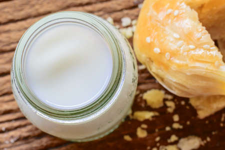 Cow's milk and buns on a dark wooden table.の写真素材