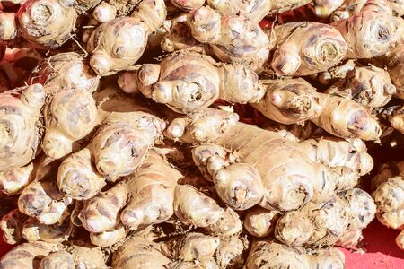 Fresh ginger at a market stall. Selective focus of ginger in a wooden