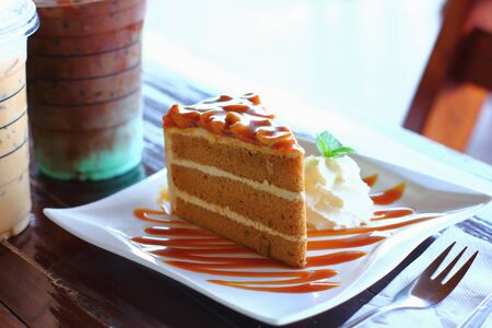 Piece of chocolate cake on a white plate on woodenの写真素材