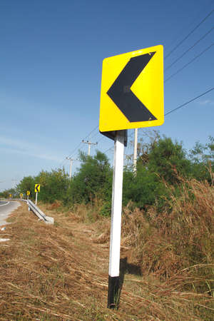 road signs indicating direction on curved road