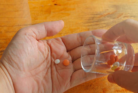 a hands holding Medicine pills or capsules in box,Pharmaceutical medicament, cure in container for...