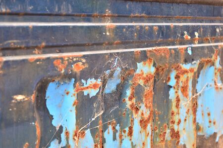 Peeling paint blue rusty textured metal background.

