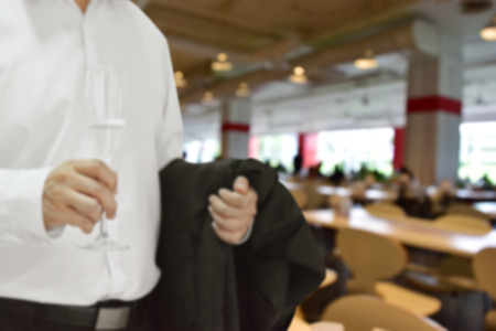 Background blur,Businessman wearing a white shirt holding a glass of champagne in a hotel banquet.の写真素材