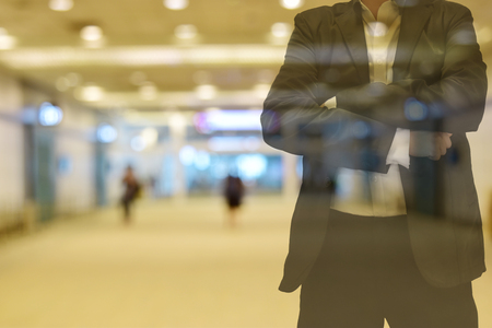 Background blur color tone warm in the morning. walkway Inside the building there are people.
Foreground is a man wearing a black suit. Can not see face and empty  left  space for text.   の写真素材