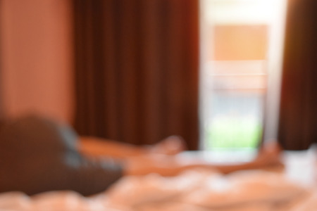 Background blur,
Men on the bed in the morning view out window and empty space for text.の写真素材