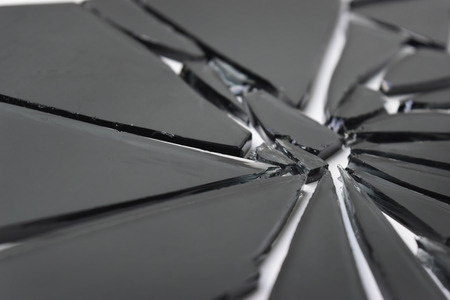 Cracked broken black transparent glass texture on white background.の写真素材