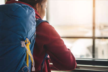 Traveler asia woman standing at the window in hall airplane departure with backpack , Selective focus, Travel concept.の写真素材