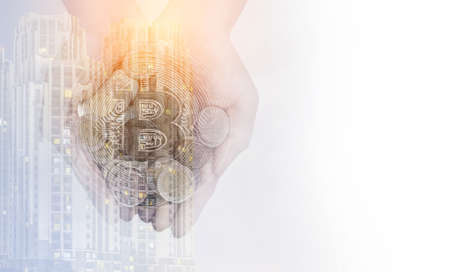 Double exposure, Cryptocurrency, A handful of Golden bitcoin in the palm of hands on view city with copy space, Mixed media.の写真素材