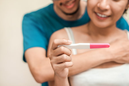 Happy young couple asian woman and man smiling and holding pregnancy test, Wellness and healthy concept, Abortion problem, Selective focus.の写真素材