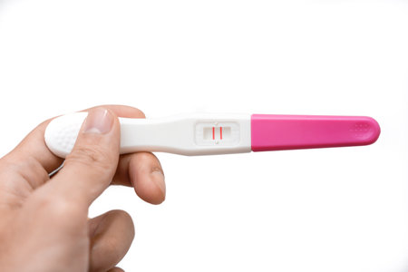 Hand holding pregnancy test showing a positive result isolate on white background, Abortion problem, Wellness and healthy concept.の写真素材