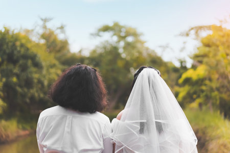 Bride and groom lovely couple hold of hands and hold flower at meadow outdoor location, copy space.の写真素材