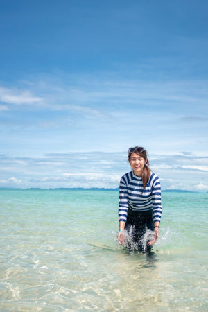 Happy smile Asian woman standing in sea water, Woman wear swimming suit, Travel vacation concept.の写真素材