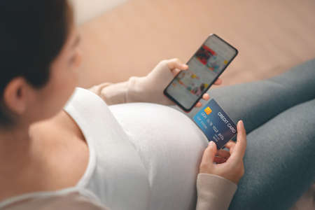 Young pregnant asian woman touching her belly, she holding baby in pregnant belly isolate on white...
