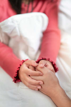 Asian mother measuring temperature girl on bed at morning time, Sick child have cool towel for reduce high fever,  Selective focus, Healthy and infection conceptの写真素材