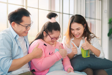 Happy asian father and mother playing education toy with their daughter down syndrome child in living room, Activity happy family lifestyle concept.の写真素材