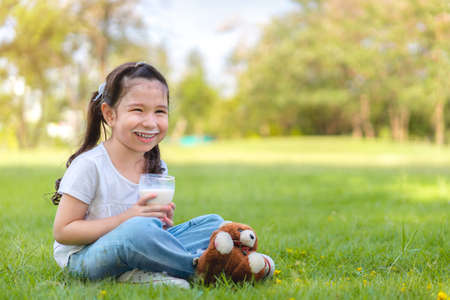 Asian caucasian mixed race girl learning to take a image from camera, Father taught her daughter, at outdoor park.の写真素材
