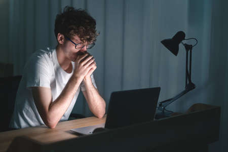 Businessman checking social media holding smartphone after work in evening time  at his office, miss work at office.の写真素材