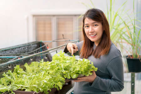 Happy pregnant asian woman choosing baby clothes at baby shop store, Prepare before Give birth baby concept.の写真素材