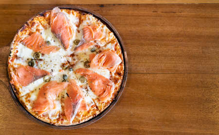 pizza with smoked salmon on wooden tableの写真素材