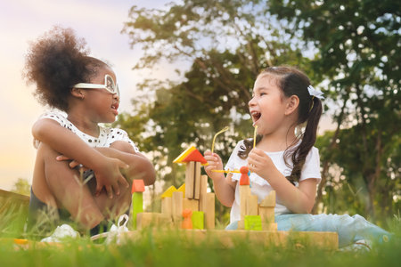 Happy cheerful white girls and black girl eat sausage together at outdoors park , Relationship...