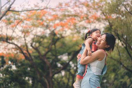 Asian mother walking with daughter in park, Parents hold the baby's in his hand , Happy family in the park evening light, Happy family concept.の写真素材
