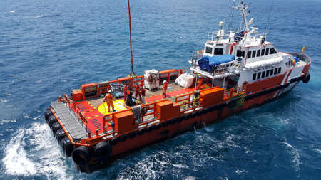 Songkhla, Thailand-February 27, 2020 : Red Supply boat transfer worker and cargo by personnel basket...