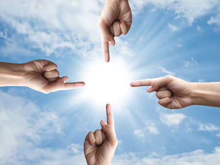 Four hand point around the sunの写真素材