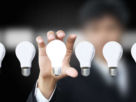 businessman holding lightbulbの写真素材