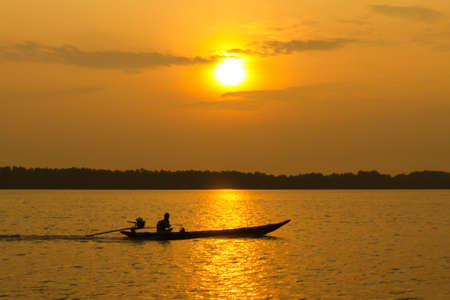 boat on the river. The sun is about to fall. Sunlight reflecting off the riverの写真素材