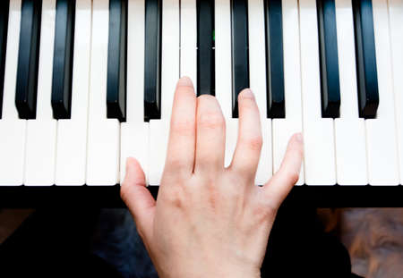 Woman's hand playing pianoの写真素材