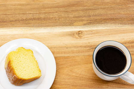 Piece of cake and black coffee on wooden table in cafe ,top view.の写真素材