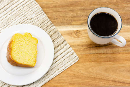 Piece of cake and black coffee on wooden table in cafe ,top view.の写真素材