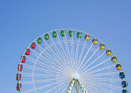 Colorful ferris wheel against bright blue backgroundの写真素材