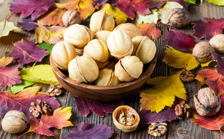 cookies nut on a brown wooden background with autumn leaves
