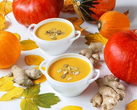 pumpkin and ginger soup against autumn leavesの写真素材