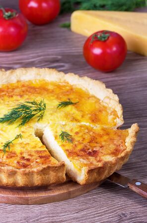 cheese and fennel pie on a round wooden board on a wooden backgroundの写真素材