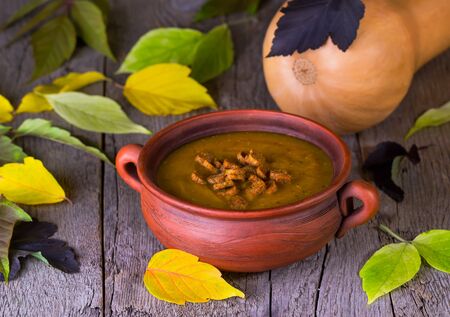 pumpkin croutons and ginger soup cream on a  background with autumn leavesの写真素材