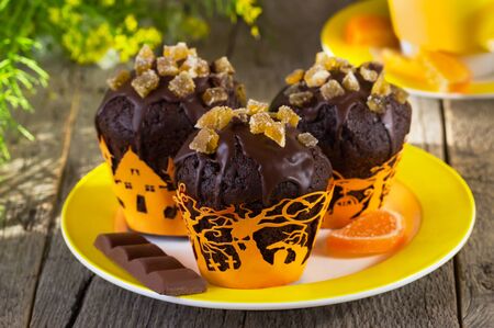 chocolate muffins on a yellow plate for Halloween on a wooden backgroundの写真素材
