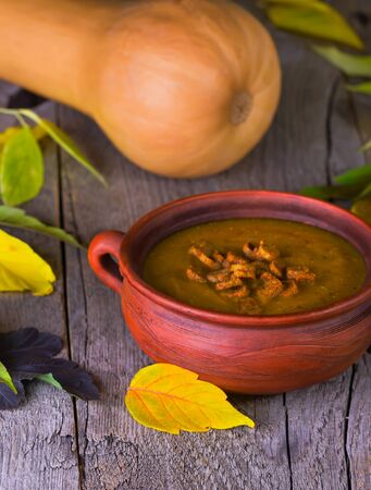 pumpkin croutons and ginger soup cream on a  background with autumn leavesの写真素材