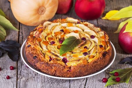 pumpkin and apples pie on a wooden backgroundの写真素材
