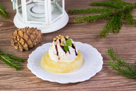 ice cream with pineapple and pine nuts on a wooden background with fir-tree branchesの写真素材
