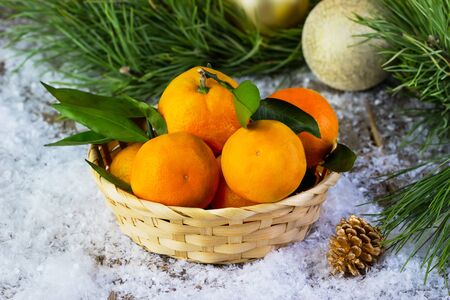 tangerines in a plate on a snow-covered background, Christmasの写真素材
