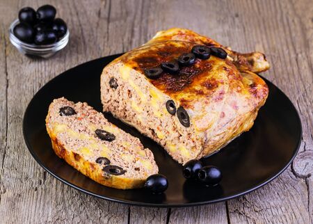 chicken stuffed with cheese and olives on a wooden backgroundの写真素材