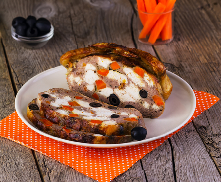 chicken stuffed with olives and carrots on a wooden backgroundの写真素材