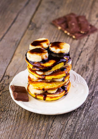 pancakes with chocolate and banana on a wooden backgroundの写真素材
