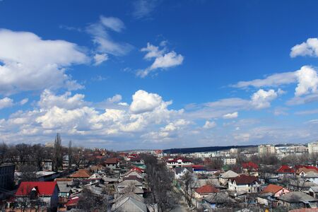 city view with blue sky and white fluffy clouds