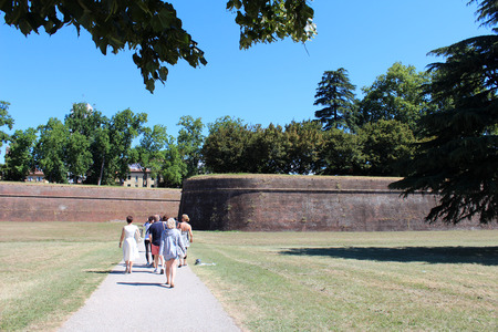 July 16, 2016, Lucca, Tuscany, Italy. People walk in front of Ancient City Walls of Lucca. Popular touristic european destination. Lucca city viewのeditorial素材
