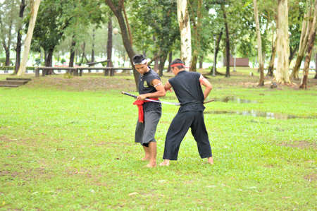 PUKED,THAILAND - AUGUST 28: Master trick of ancient fighter on August 28, 2011 in Puked Thailand.  Master show how to trick of fight with swords.のeditorial素材