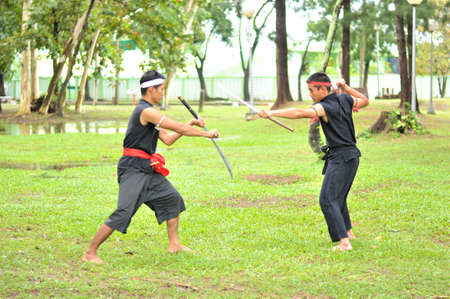 PUKED,THAILAND - AUGUST 28: Master trick of ancient fighter on August 28, 2011 in Puked Thailand.  Master show how to trick of fight with swords.のeditorial素材