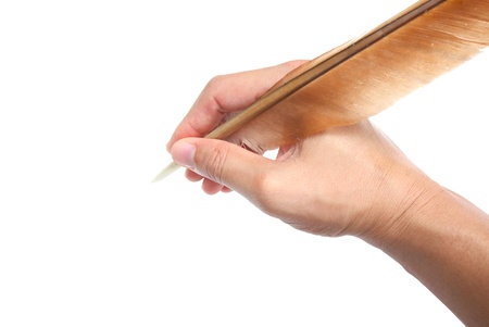 hand and feather pen over white background の写真素材